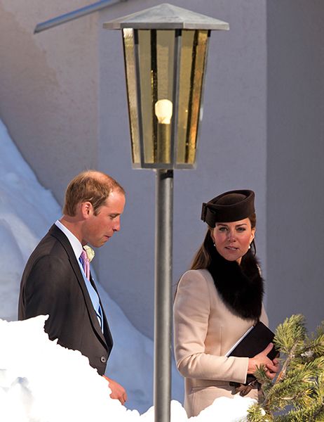 Prince William and Princess Kate walking past a lamppost