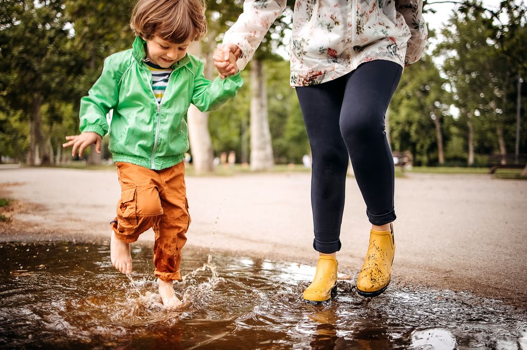 Happy family playing in the street after a rain.