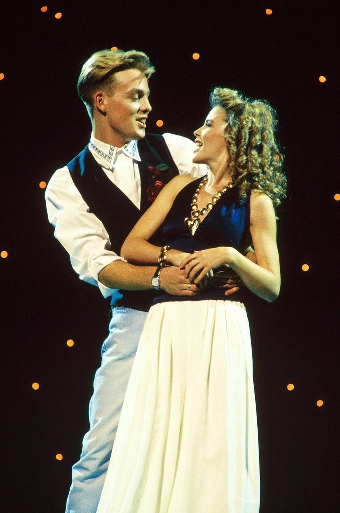 Jason Donovan and Kylie Minogue singing and dancing