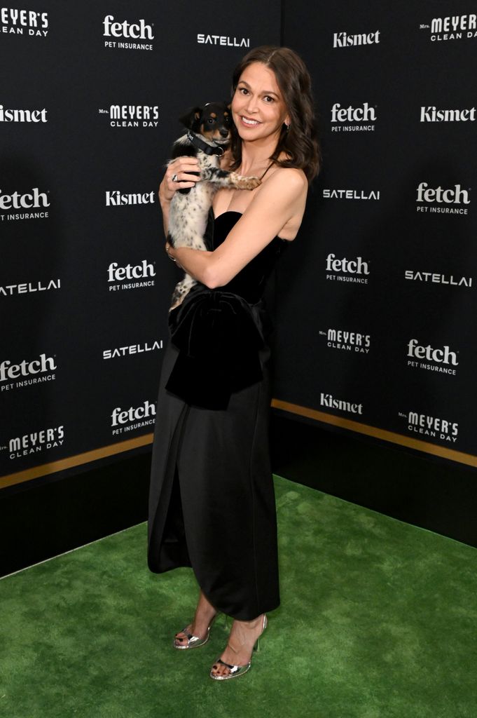 Sutton posed with a rescue pup on the green carpet