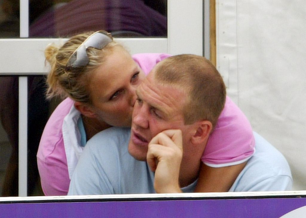 Zara Phillips in a pink top kissing Mike Tindall on the cheek