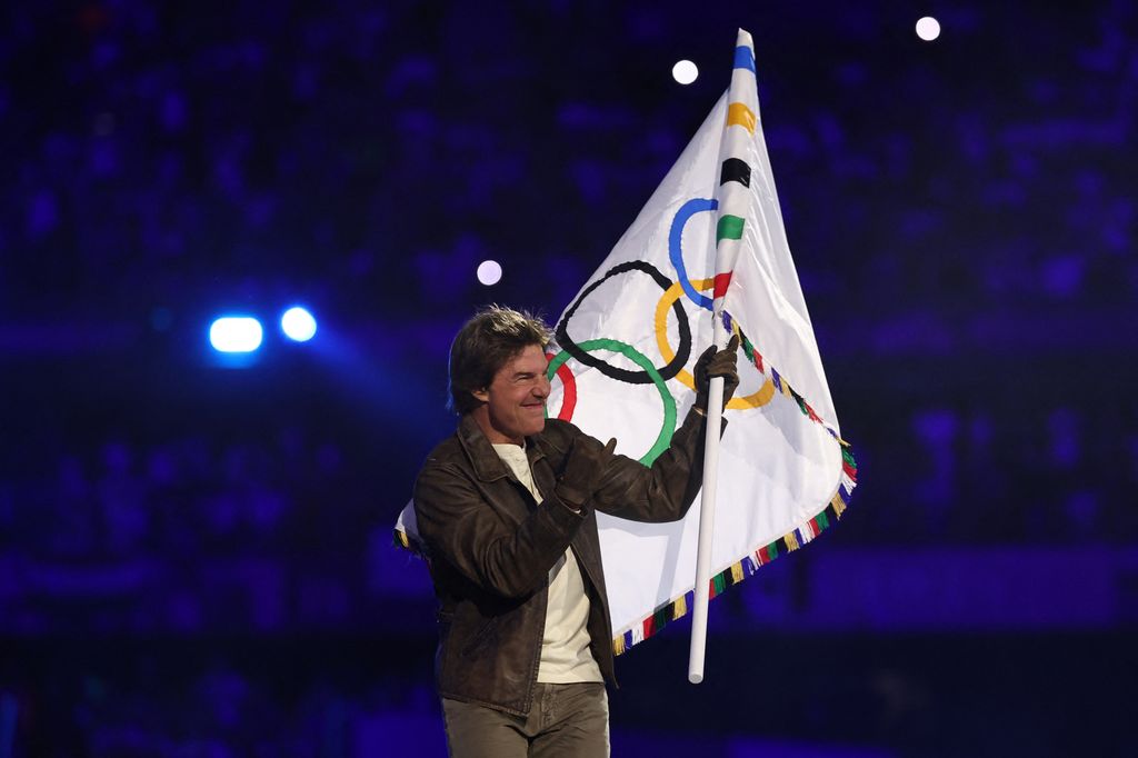 Tom Cruise waves the Olympic flag 