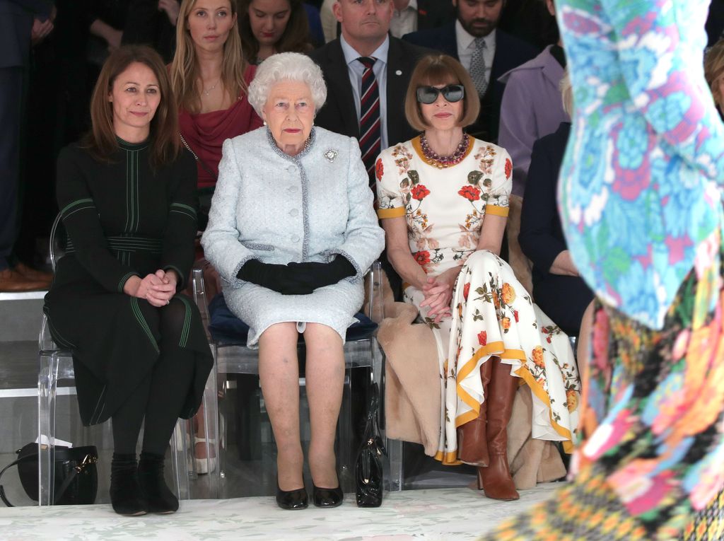 Queen Elizabeth is flanked by Anna Wintour and Caroline Rush, chief executive of the British Fashion Council, as they sit front row at a London fashion show in February 2018