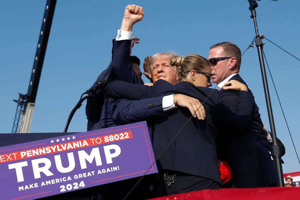 Republican presidential candidate former President Donald Trump pumps his fist as he is rushed offstage during a rally on July 13, 2024 in Butler, Pennsylvania