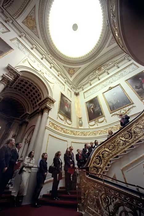 a grand circular staircase lined with people leading up to reveal a huge skyline