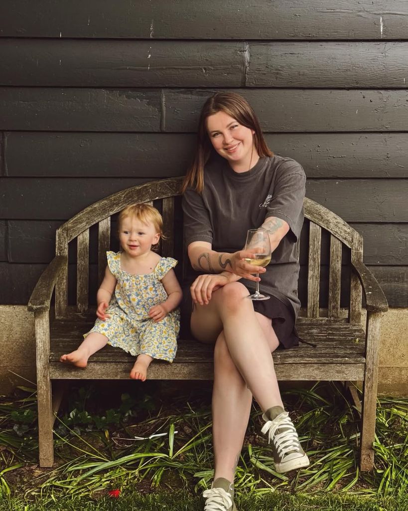 Ireland smiling holding a glass of wine next to her daughter Holland