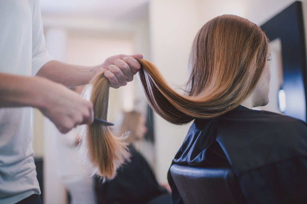 Woman with long hair getting her hair cut