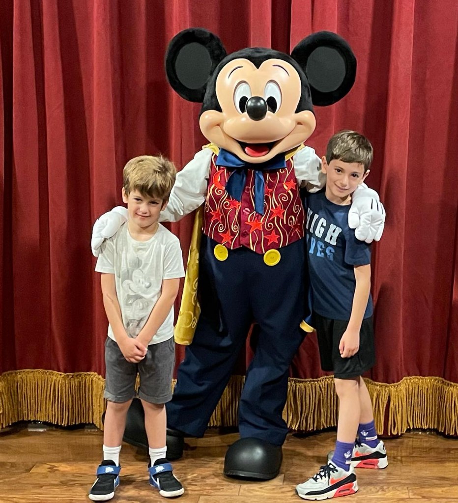 Photo shared by Ginger Zee on Instagram November 2023 where her two sons Adrian and Miles are posing next to Mickey Mouse at Disney World in Orlando, Florida.