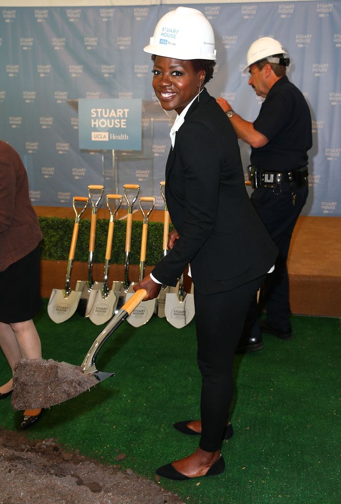 Actress Viola Davis holds a shovel wearing a helmet