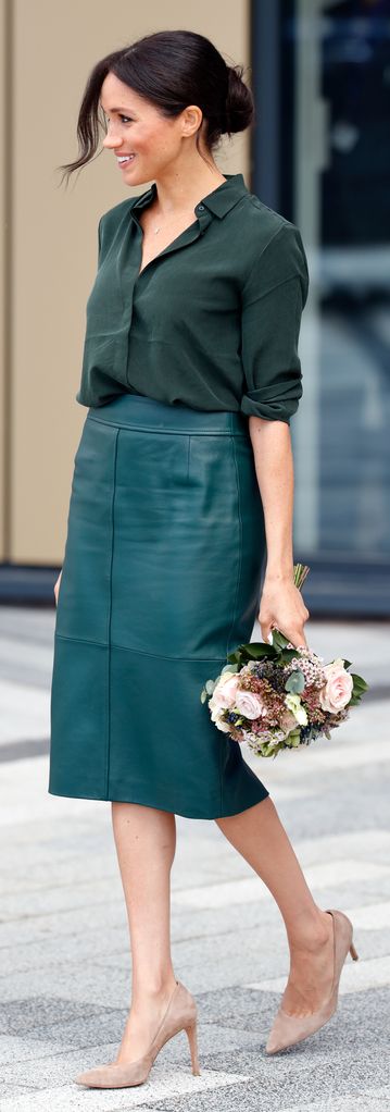 Meghan Markle in a green pencil skirt carrying flowers