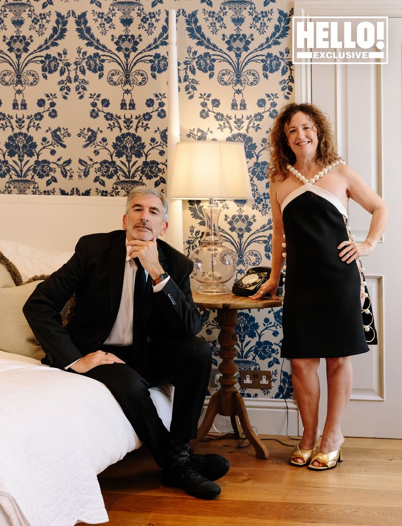 peter and sara in bedroom of hotel with blue floral wallpaper