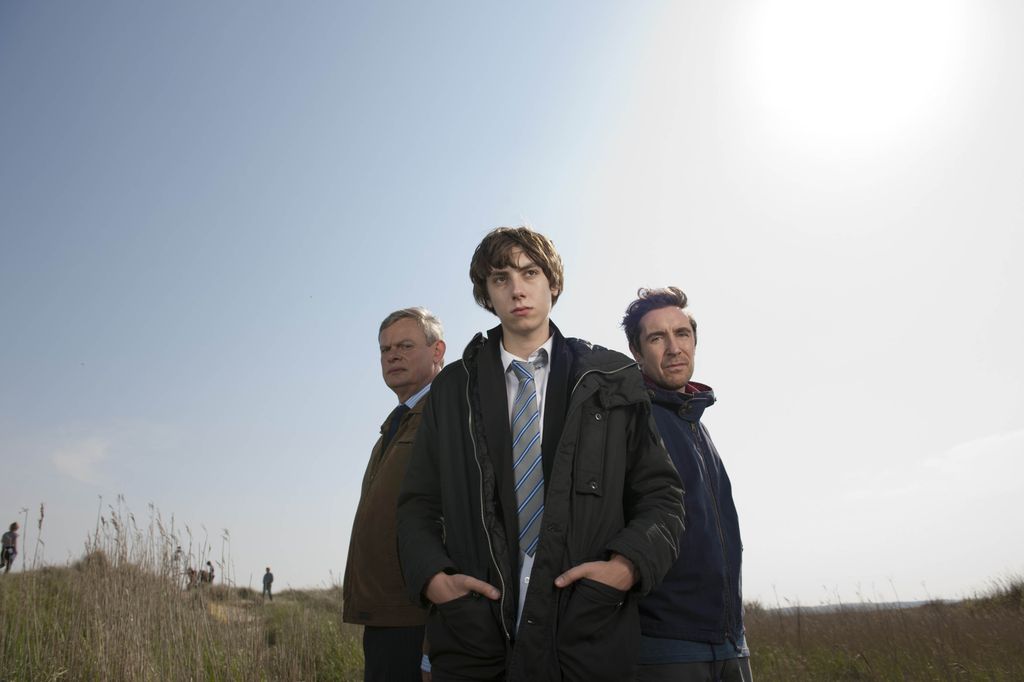 Teenager who stands in front of two men on the field
