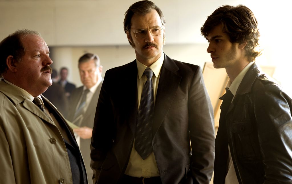 three men in suits talking in office