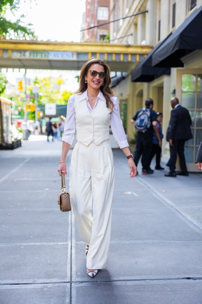 Queen Rania in a shirt and waistcoat walking in New York