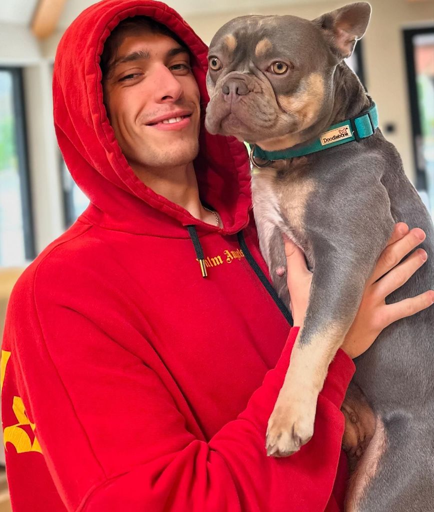 john bishop's son holding dog in red jumper