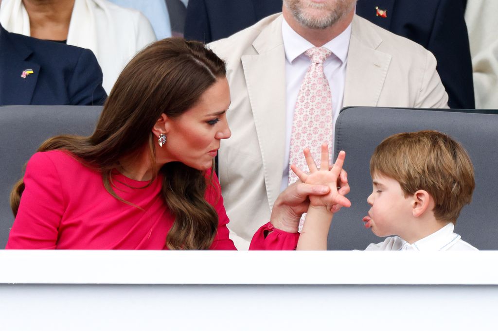 Prince Louis of Cambridge 'thumb's his nose' and sticks his tongue out at his mother Catherine, Duchess of Cambridge as they attend the Platinum Pageant on The Mall on June 5, 2022 in London, England.
