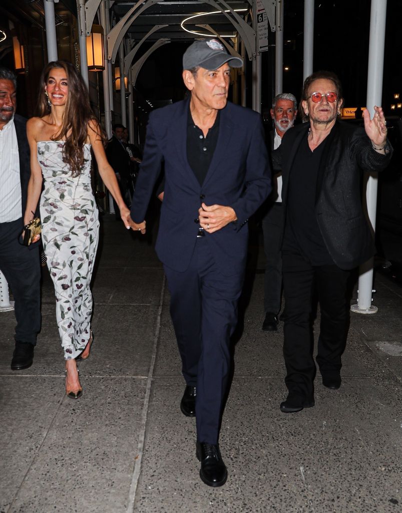 *EXCLUSIVE* - American actor and filmmaker George Clooney and wife Amal Clooney are seen holding hands as they leave Polo Bar in New York City after enjoying dinner with Bono sharing a warm and intimate moment amid the bustling evening.