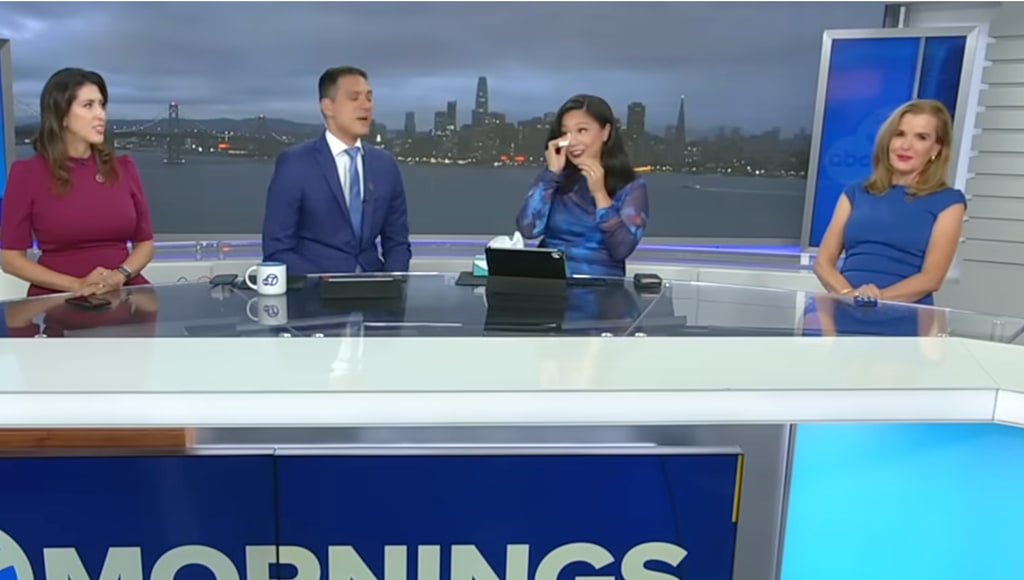 Reggie in navy suit sat in studio with co-hosts