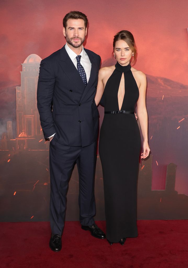 Liam Hemsworth in black suit and Gabriella Brooks in black dress at The Witcher premiere