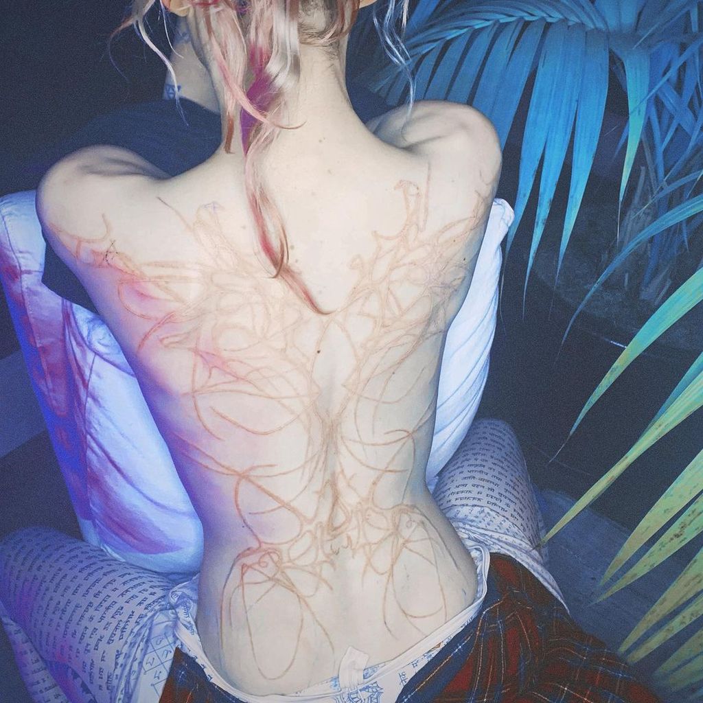 Grimes revealed her back tattoo in April 2021