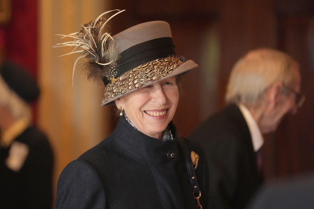 Princess Anne wearing dark coat and feathered hat