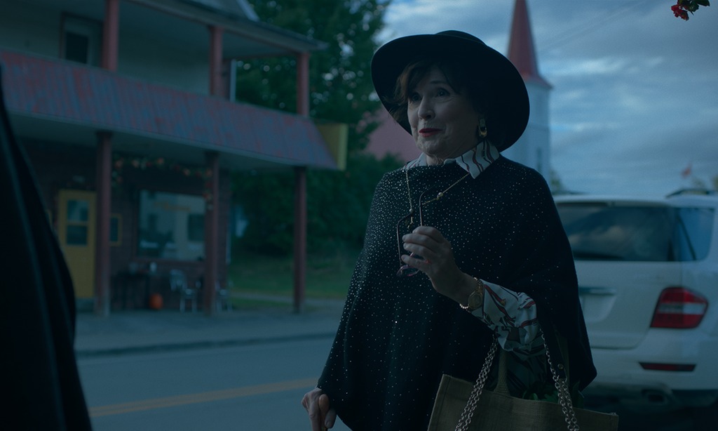 woman in hat standing in street