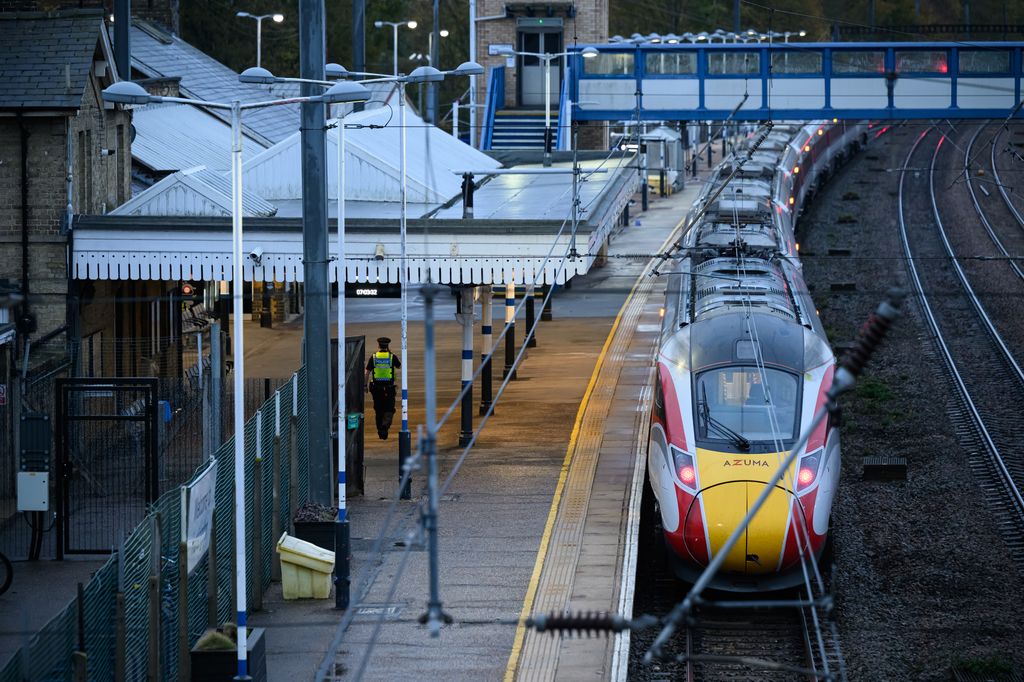 An empty train in a station with a police officer walking past