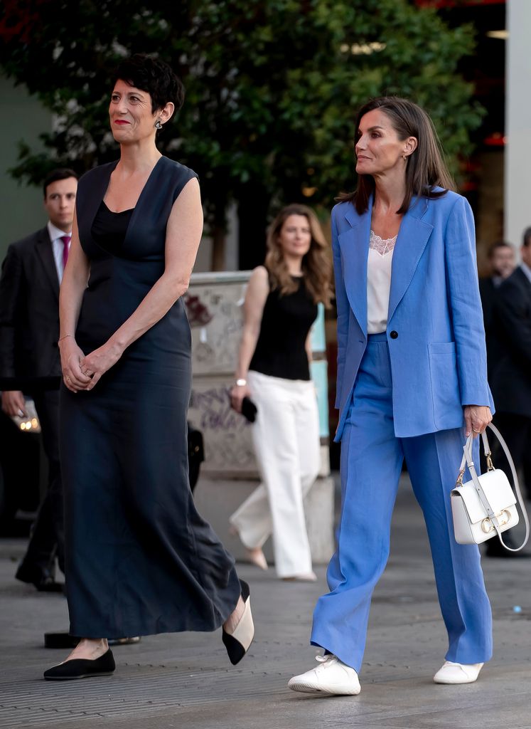 Queen Letizia of Spain in blue suit and Elma Saiz Delgado walking