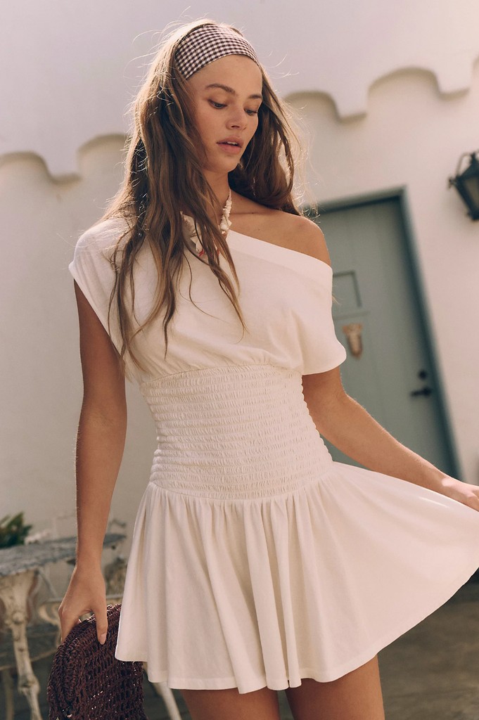 A model poses for Free People in a white mini dress