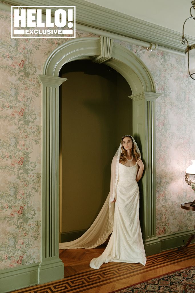 Tessa Mossey stands against an archway in her wedding gown