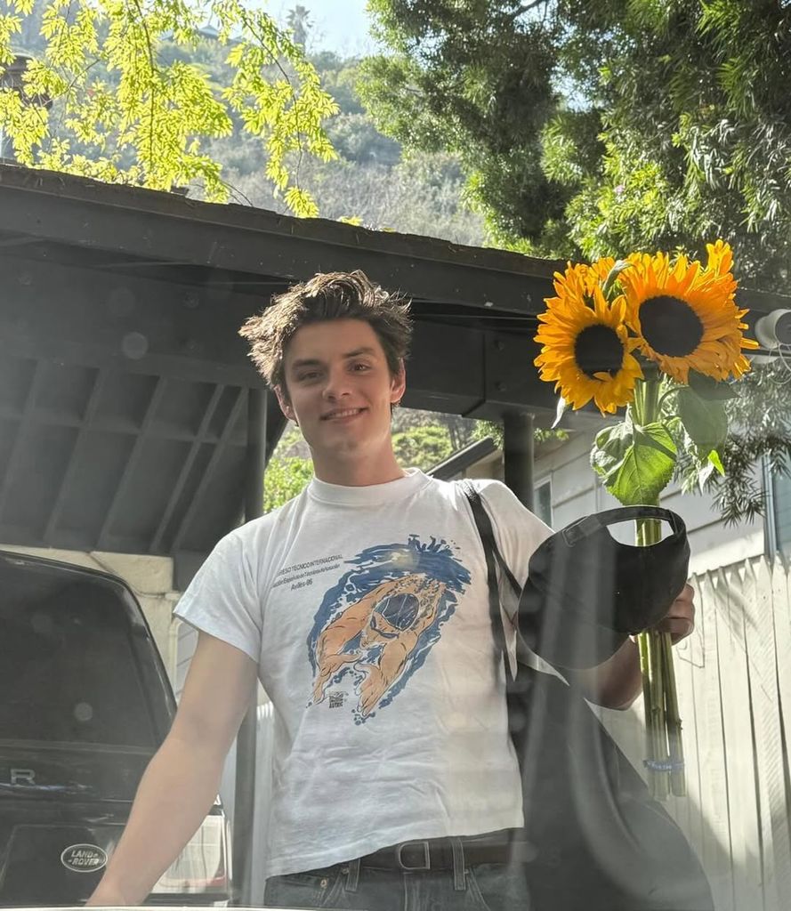 A man holding sunflowers