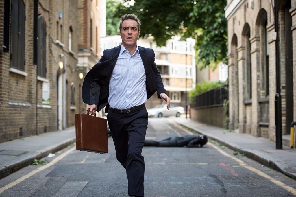 man running in street with suitcase