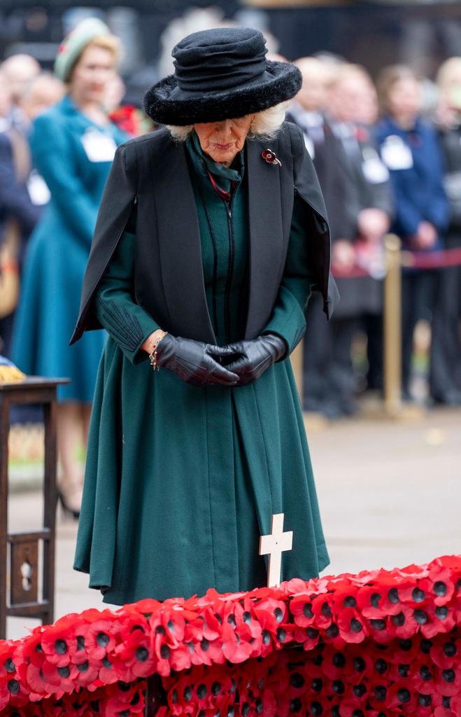 Queen Camilla pauses after placing memorial cross