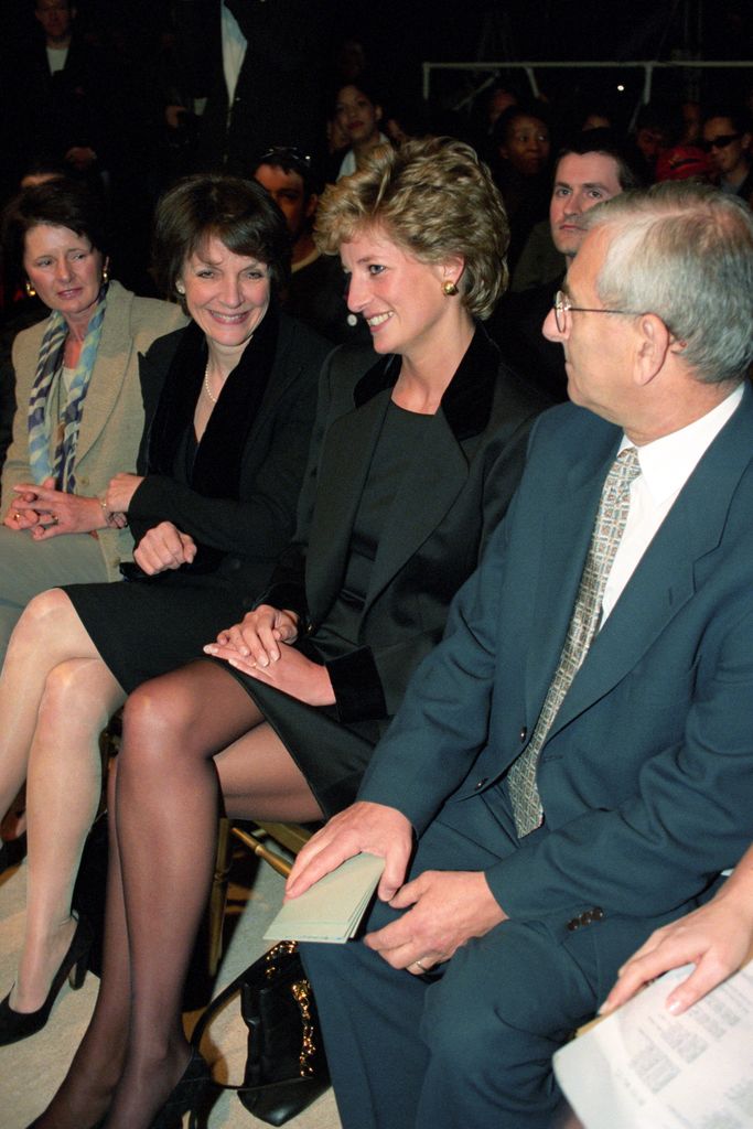 Princess Diana wears a black suit as she sits next to Anna Harvey (Vogue Deputy Editor) at London Fashion Week