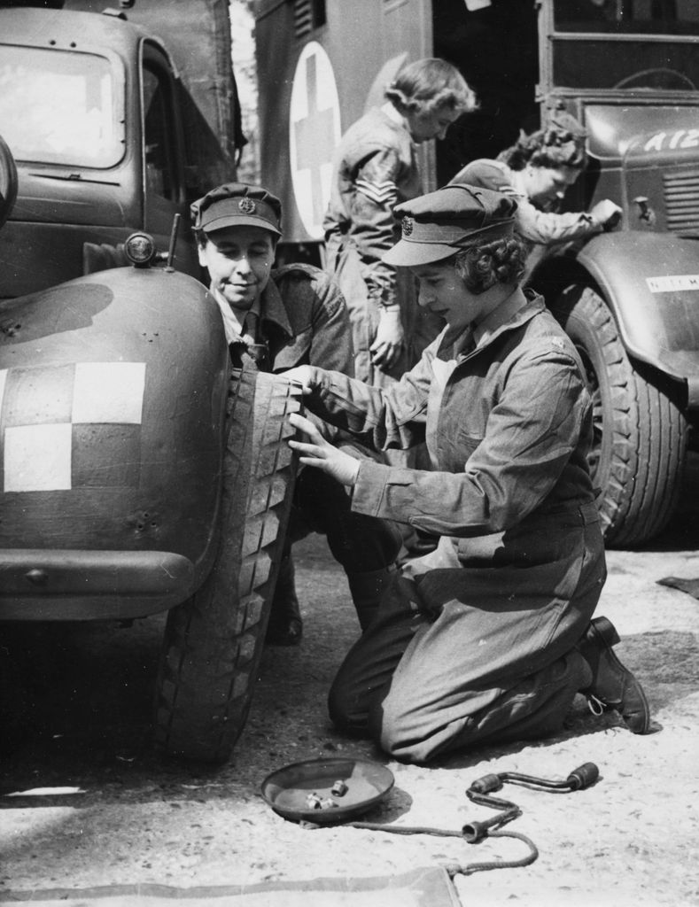 Princess Elizabeth changing the tire of a vehicle as she trains at as ATS Officer during World War Two, at the ATS training centre in 1945