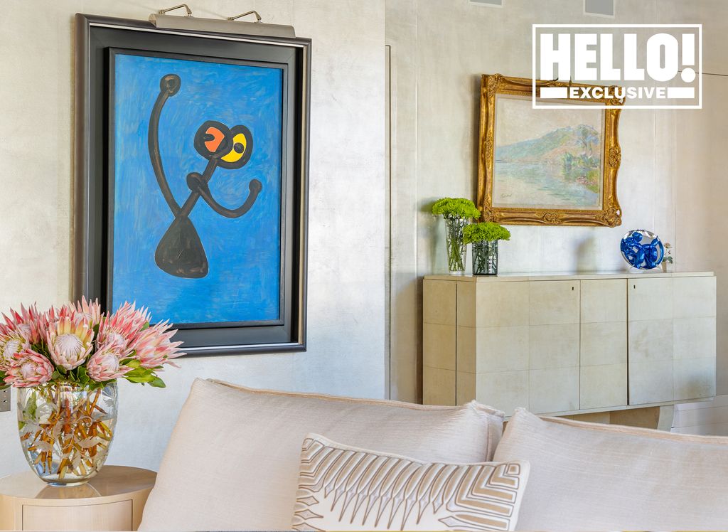 Celia Kritharioti living room with blue artwork gold framed painting and pink flowers