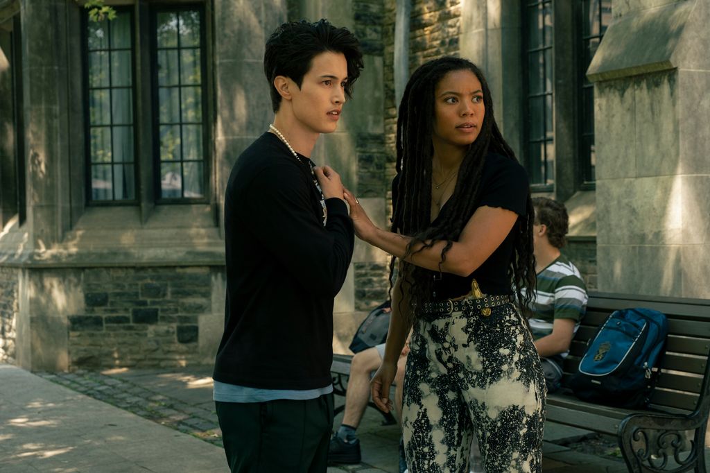two teens standing outside old building/school 
