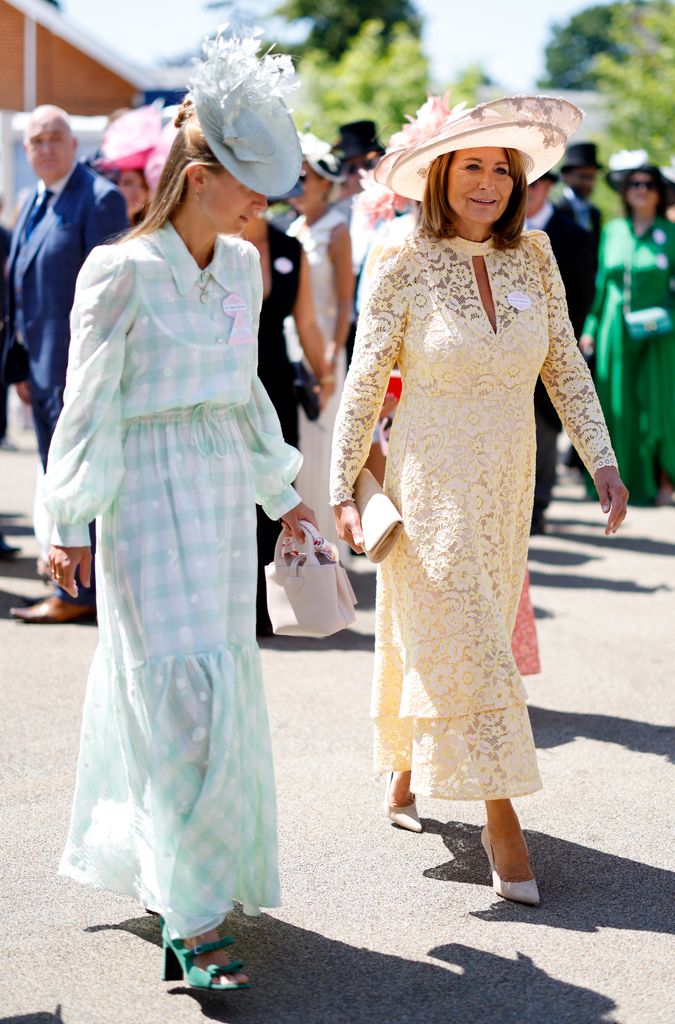 Alizee dengan topi hijau dan gaun berjalan di samping Carole Middleton dengan warna kuning