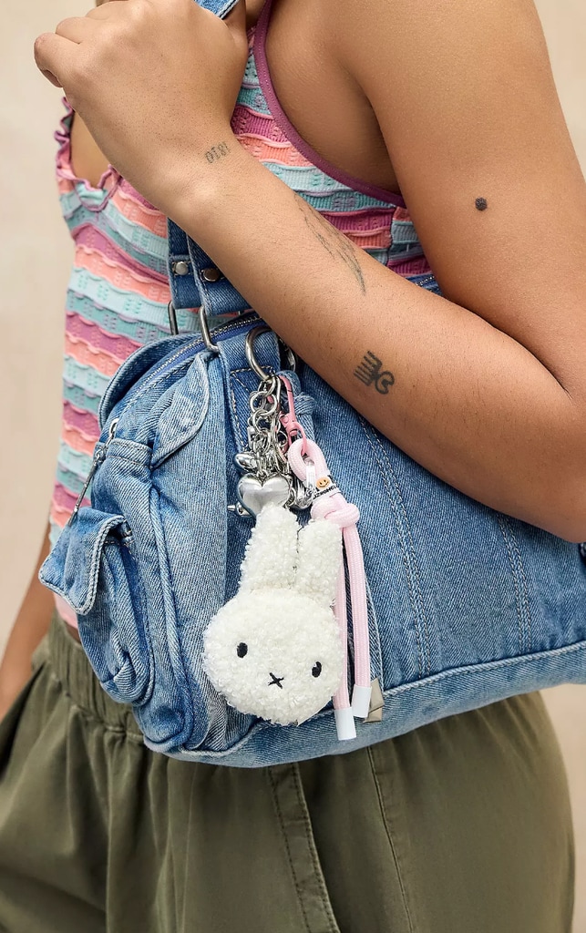 A Miffy head keychain attached to a denim bag 