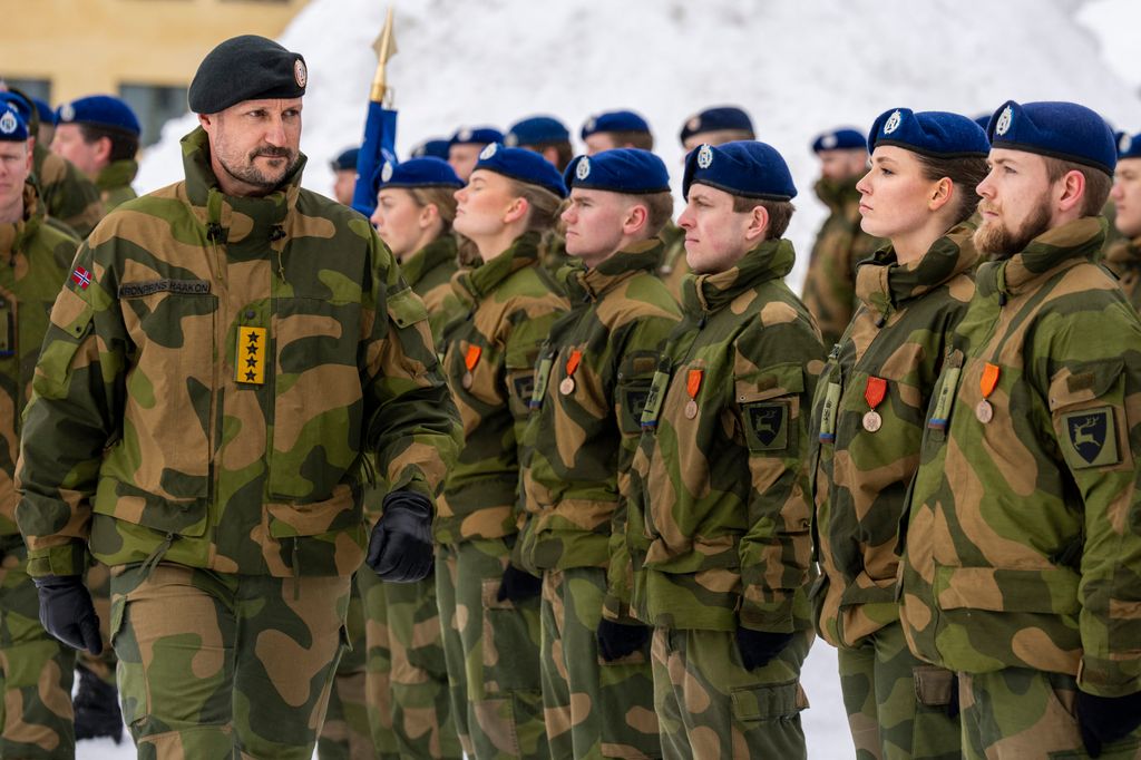 Princess Ingrid Alexandra stood upright alongside others dressed in military wear