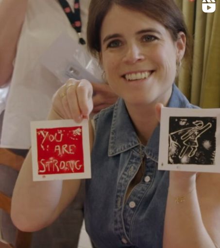 Princess Eugenie holding up lino prints at Salvation Army