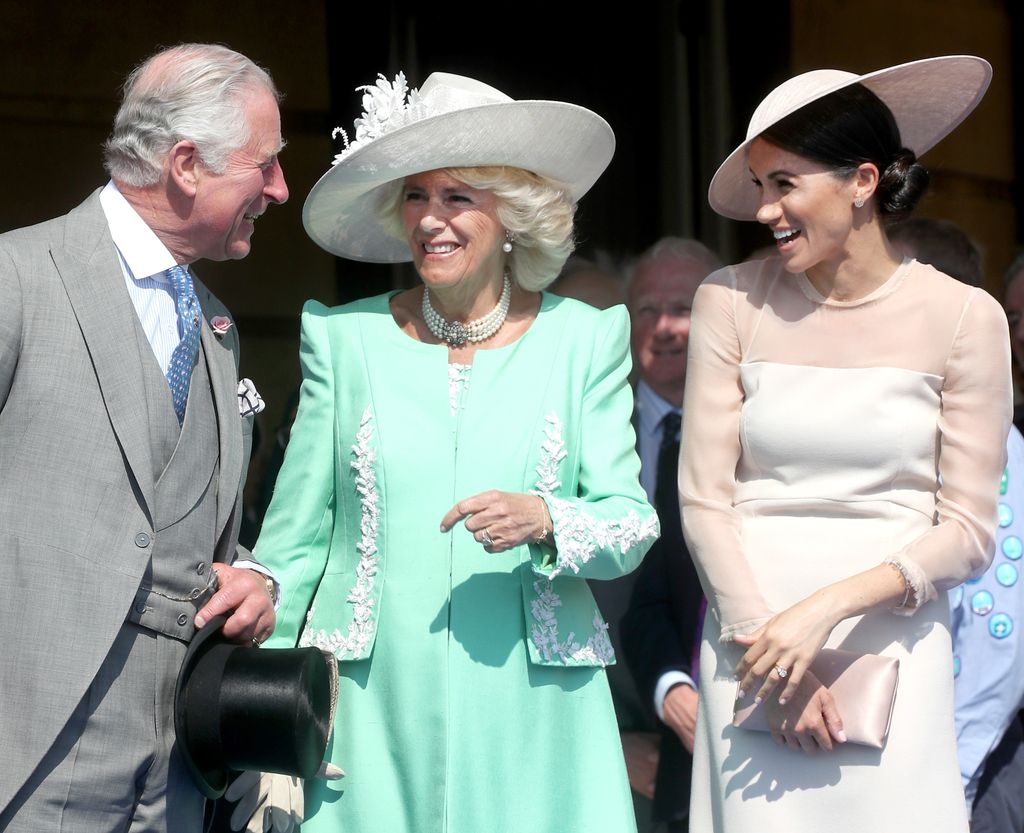 A photo of Meghan Markle laughing with Charles and Camilla 