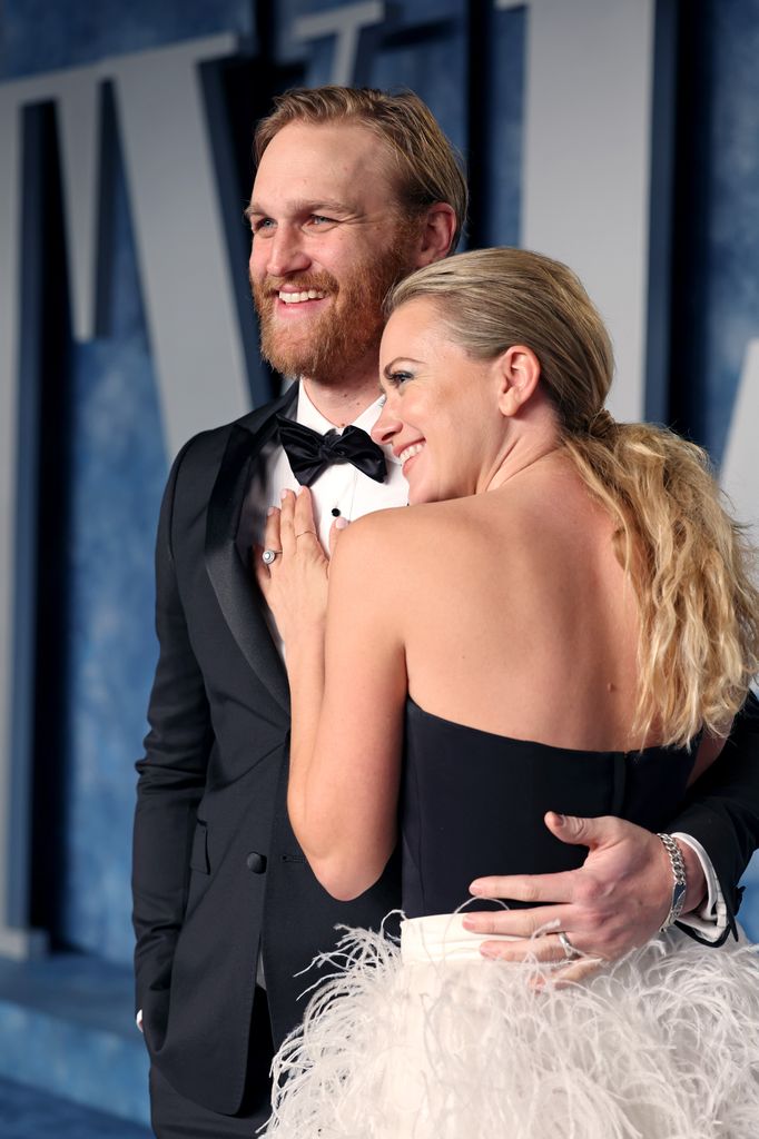 Wyatt Russell and Meredith Hagner hug on the red carpet