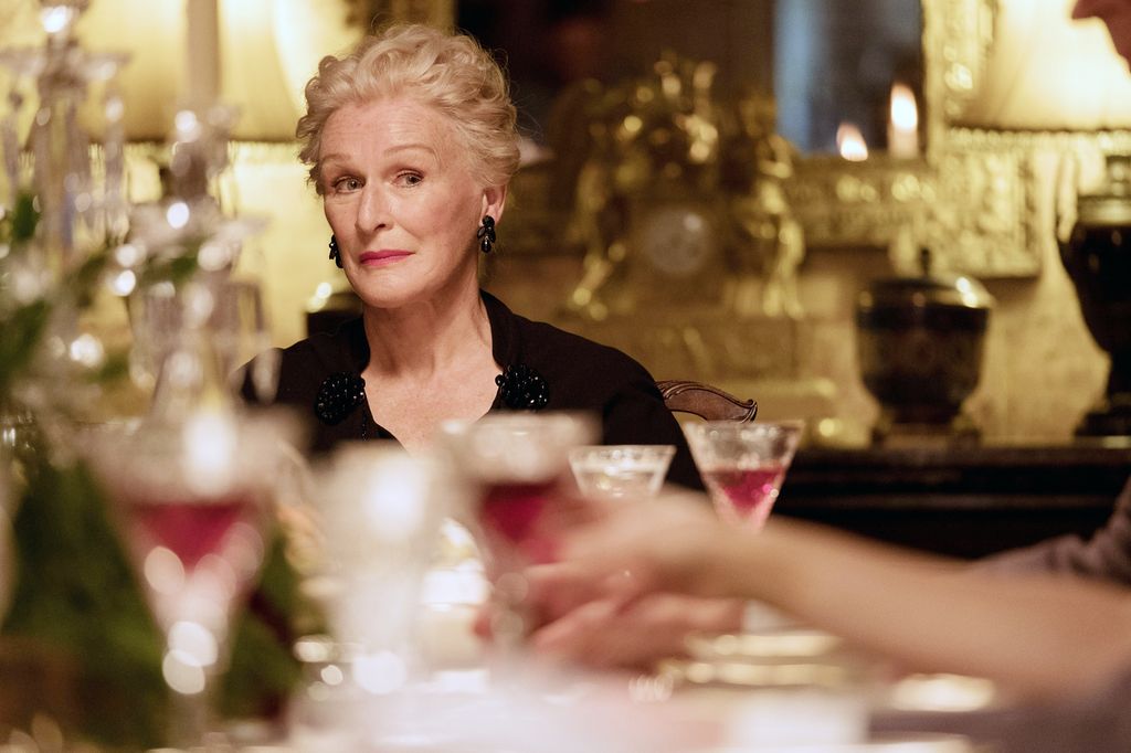 Woman with short curled hair sitting at table 