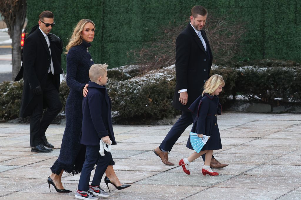 Lara Trump dalam perjalanan menuju Pelantikan bersama anak-anaknya dan Eric Trump: ia memancarkan keanggunan abadi dalam mantel panjang bertekstur biru tua yang dihiasi kancing perak mencolok.