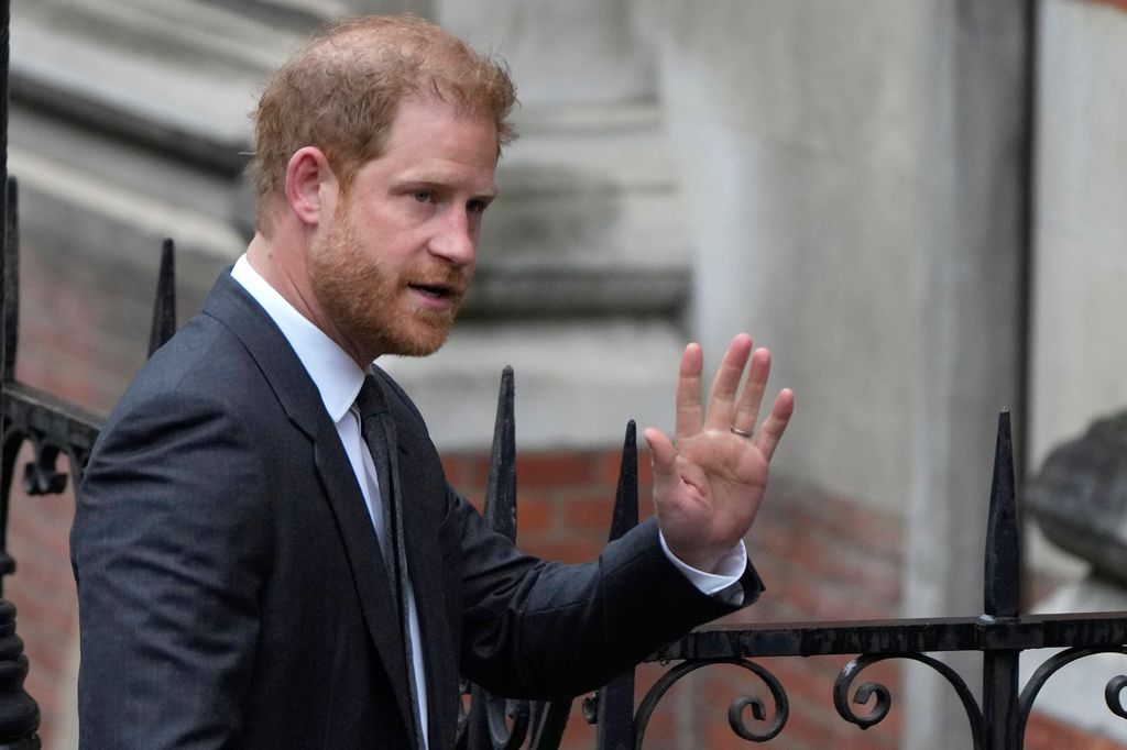 Prince Harry waves to the media as he arrives at the Royal Courts Of Justice in London