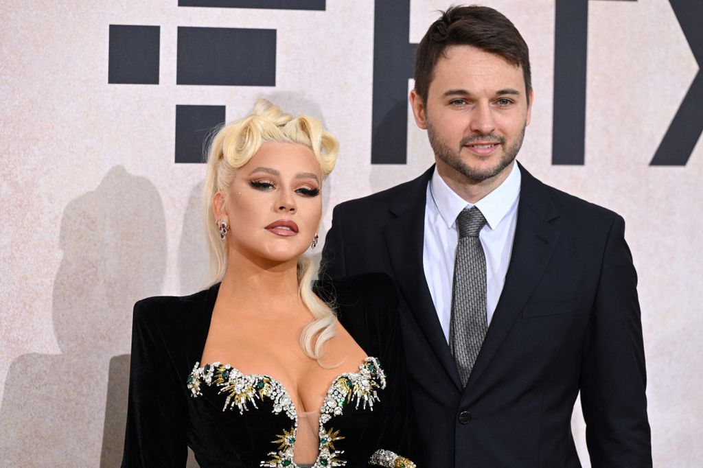 Christina Aguilera wows in plunging black dress as she joins Matthew Rutler 