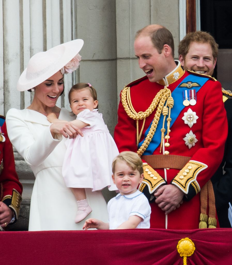 Kate Middleton holding a baby Princess Charlotte alongside Prince George, Prince William and Prince Harry