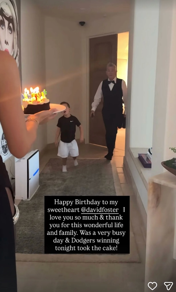 Katharine McPhee is seen holding a lit birthday cake while walking toward a smiling David Foster