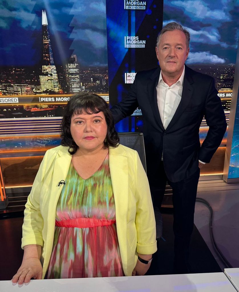 Piers Morgan next to Fiona Harvey, who is sitting in a chair
